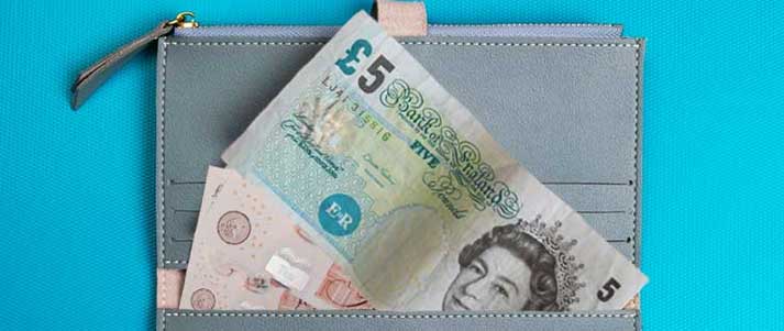 five and ten pound note in a purse