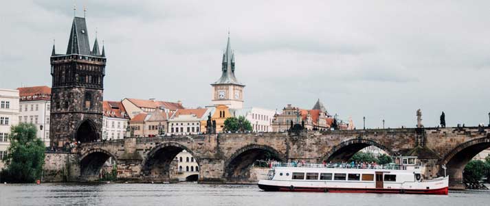 boat in front of the charles bridge in prague