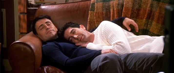 Joey and Ross from Friends napping together on a sofa