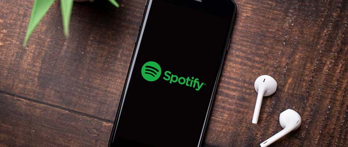 spotify on phone on a table with earpods