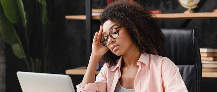 Tuition fees rise with inflation, maintenance loans will not rise... » Earn Money Woman looking at laptop screen nervously