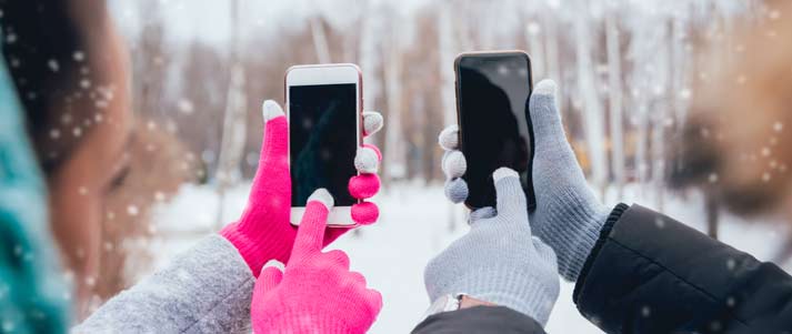 hands in touchscreen gloves touching phones