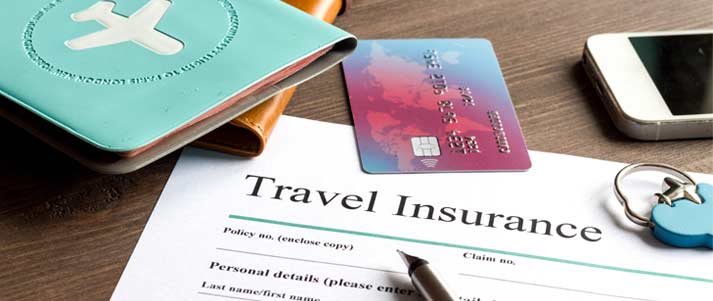 travel insurance contract on table with a credit card a phone passport and pen