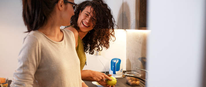 two women cooking together in kitchen