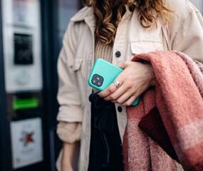 woman holding blue phone case on walk
