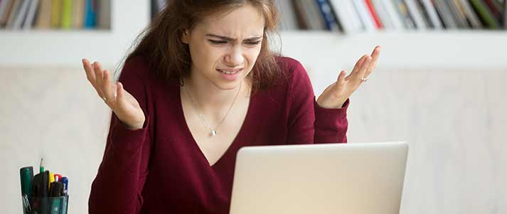 Mujer encogiéndose de hombros en la computadora portátil