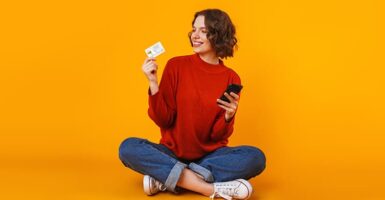 woman holding card and mobile