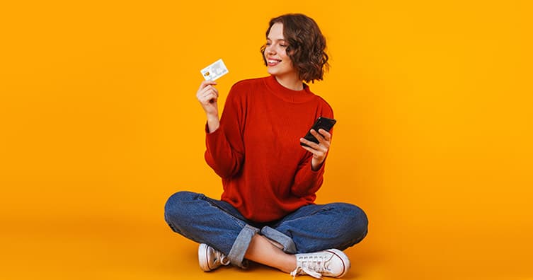 woman holding card and mobile