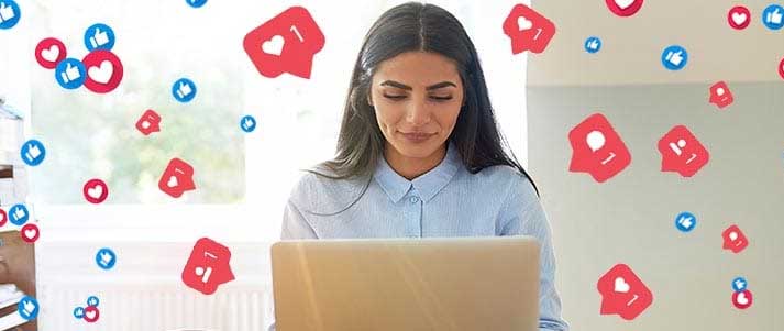 Woman on laptop with social media likes and loves