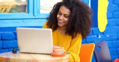 woman on laptop in colourful cafe