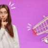 woman holding finger in front of her lips and shopping cart