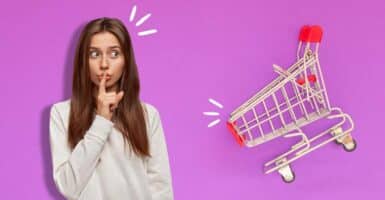 woman holding finger in front of her lips and shopping cart