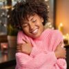 Woman hugging herself with candles in the background