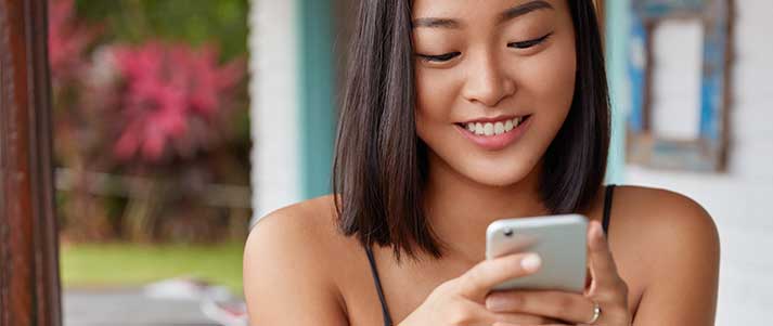 woman smiling using phone