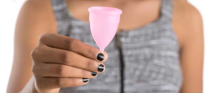 woman holding a menstrual cup