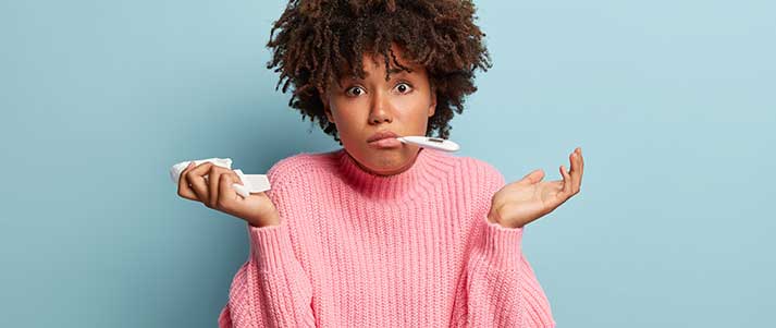 Woman shrugging with thermometer