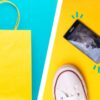yellow shopping bag and broken phone by shoes